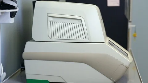 Female genetics worker placing the strips with DNA into the PCR thermal cycler Stock Footage 93345463