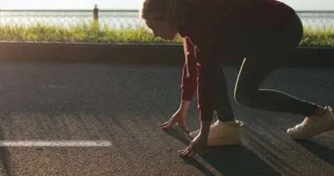 Female gets up and gets ready to run in the morning at dawn. Close up of young Vidéo 137329680