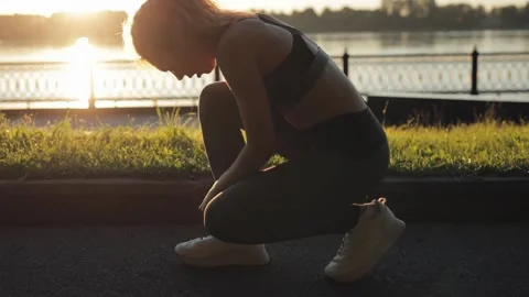 Female gets up and gets ready to run in the morning at dawn. Close up of young Stock Footage 137329791