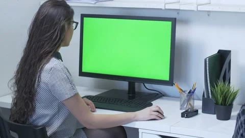 Female with glasses in front of large computer monitor with green screen Stock Footage 142208065