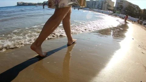 Female goes along sea beach in slow motion mode Stock Footage