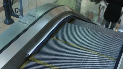 Female going down using escalator stairs metal stair steps moving escalator Stock Footage 221200167