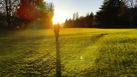 Female Golfer with Shadow Making Practice Golf Swing and Hitting the Golf Ball 動画素材 265061178