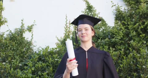 Female graduate in gown cap pulling diploma, tossing catching while celebrating Stock Footage 335165751