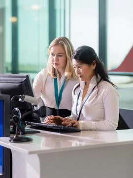 Female Ground Staff Using Computer At Reception In Airport 写真素材