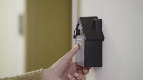 Female guest openings up a code box for a piece of real estate on the market, Stock Footage 267765710