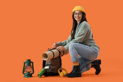 Female guide with backpack and lantern on orange background Stock Photos