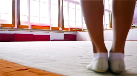 Female gymnast training on the floor of a gym, slow motion Stock Footage