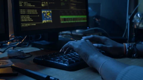 Female Hacker Coding on Computer Keyboard while Launching Cyberattacks at Night Stock Footage 328244288