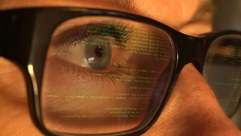 A female hacker compiling code with the computer screen reflected in her glasses Stock Footage 85811787
