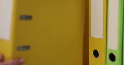 Female hand of accountant pulls binder folder from storage shelf Stock Footage 276448917