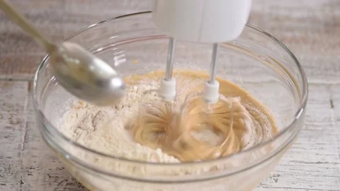 Female hand adding flour to the dough and beat with a mixer. Video stock 156676646