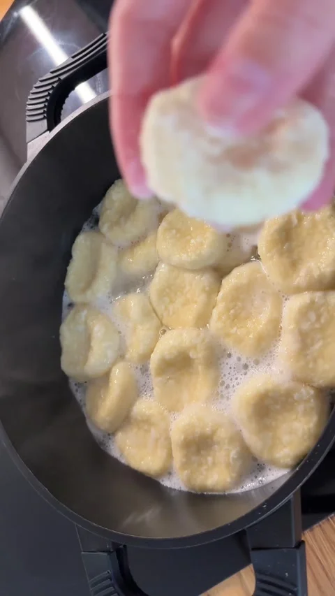 Female Hand Adding Homemade Cottage Cheese Dumplings to Boiling Water Stock Footage 344602189