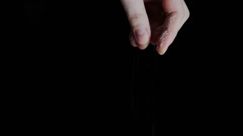 Female hand adding white salt to dish against black background Stock Footage 143984067