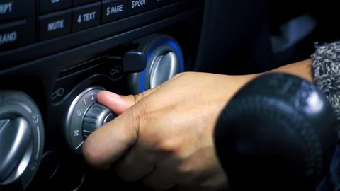 Female hand adjusting button control air conditioning on a vehicle Stockbeeldmateriaal 77780755