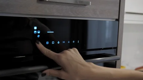 Female hand adjusts the necessary parameters in the oven, close-up Stock Footage 126152433