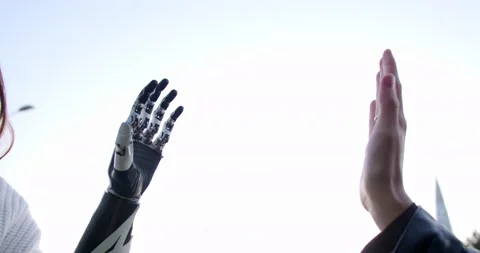 The female hand and the bionic hand of the second person give each other a high Stock Footage 160062428
