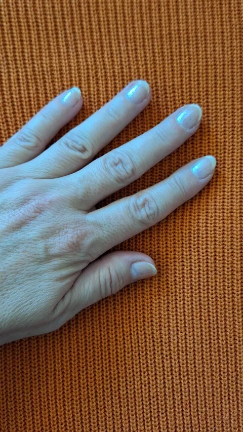 Female hand on a background of orange fabric close-up. Video stock 346493077