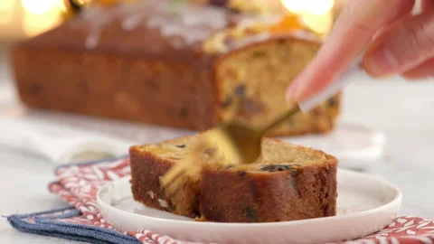 Female hand breaks off a piece of a fork sliced fruitcake. Christmas atmosphere Stock Footage 145369731