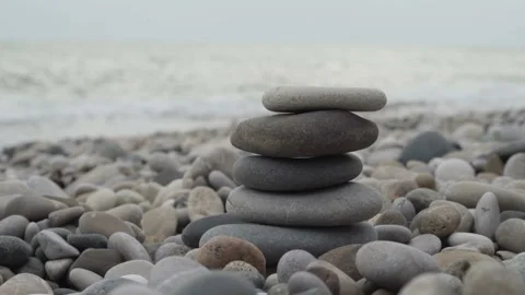 Female hand building a stack of stones on the beach Stock Footage 95844595