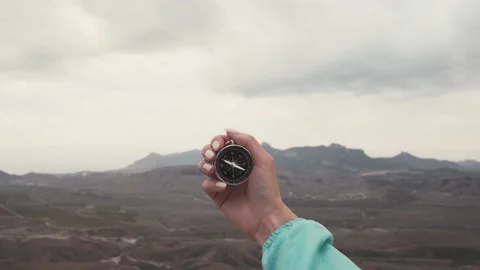Female hand with a compass in front of mountains. Stock Footage 146025330