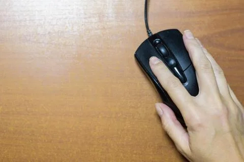 Female hand with computer mouse on table Stock Photos