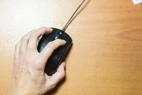 Female hand with computer mouse on table Stock Photos