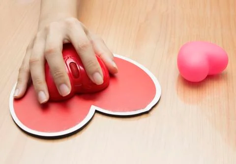 Female hand with computer mouse on table.valentine day Stock Photos
