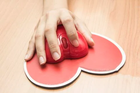 Female hand with computer mouse on table.valentine day Stock Photos
