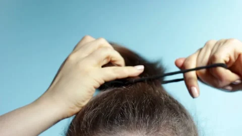 Female hand correct the bun on blue background. Stock Footage 149159164