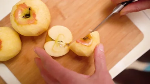 Female hand cut apple slice on wooden chopping board Vidéo 143964073