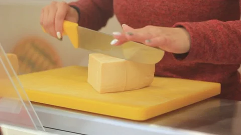 Female hand cuts cheese with a knife on the board Stock Footage 116802425
