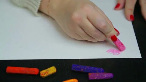 Female hand draws evening clouds on white paper with pink chalk Stock Footage 122040431