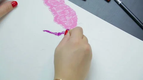 Female hand draws evening clouds on white paper with purple pastel Stock Footage 126115174