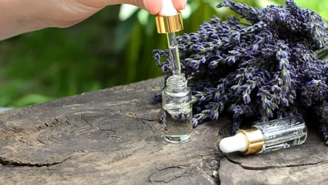 A female hand draws lavender essential oil into a dropper Stock Footage 157724086