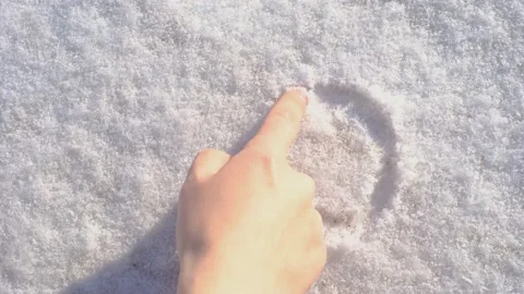 Female hand draws a question mark on the snow close-up. Stock Footage 228708231