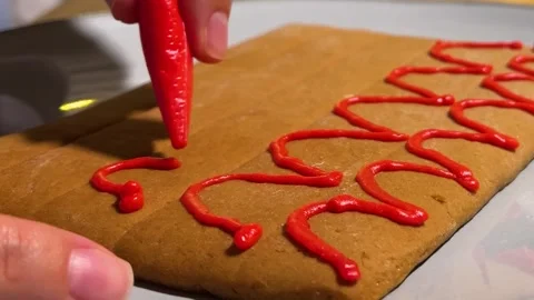 Female hand draws wavy pattern on gingerbread cookie Stock Footage 323236721