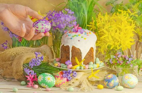 Female hand with Easter eggs. Table decorating for Easter holiday. 스톡 사진