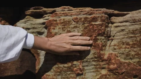 Female hand gently touching rough sandstone texture, connecting with nature Stock Footage 308319684