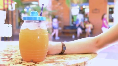 Female hand grabs refreshment drink on an outdoors setting on a summer day Video stock 109085599