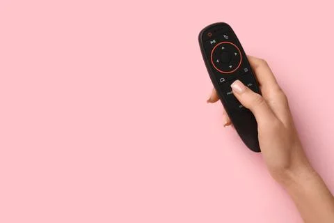 Female hand with gyroscopic remote controller on pink background 库存照片