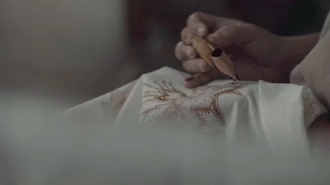 Female hand holding canting for making of batik painting Stock Footage 221258997