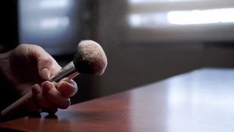 Female Hand Holding Makeup Brush With Floating Powder Particles In Sunlight Stock Footage 330299525