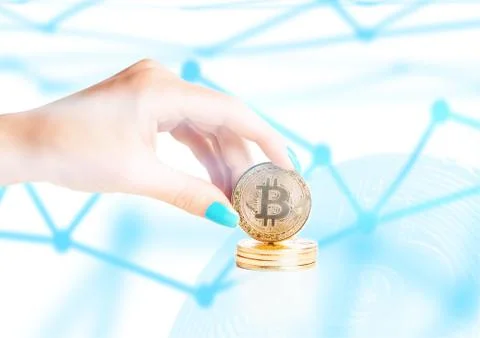 Female hand holding stack of gold bitcoins, blockchain concept. Stock Photos