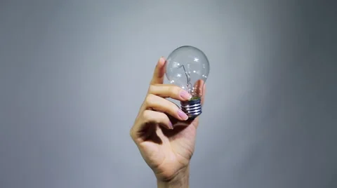 Female hand holds and turns the light bulb Stock Footage 59643547
