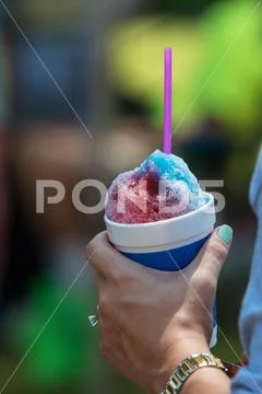 Female Hand Holds Snow Cone In Cup At Summer Festival Stock Photos