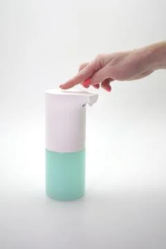 Female hand includes automatic dispenser, sanitizer on an isolated background Stock Photos