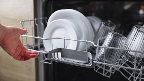 Female hand insert and load basket of opened kitchen dishwasher machine Stock Footage 171863484