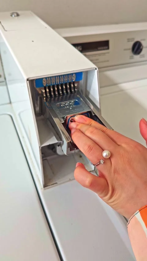 Female hand inserting coins into coin-operated washing machine Stock-Footage 321999752