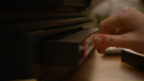 Female Hand Inserting Retro VHS Tape into Vintage Vcr Player Stock Footage 337909626